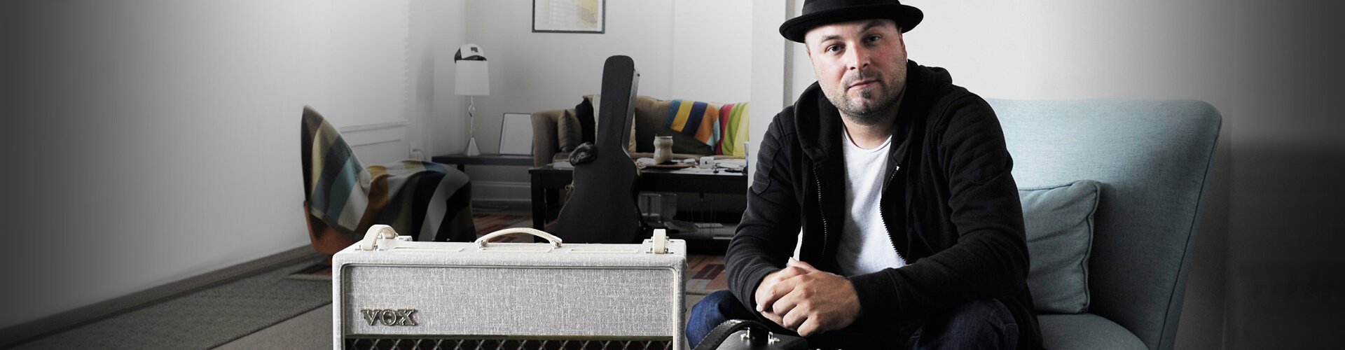 artist, Guthrie Trapp, sitting in appartment beside VOX amplifier
