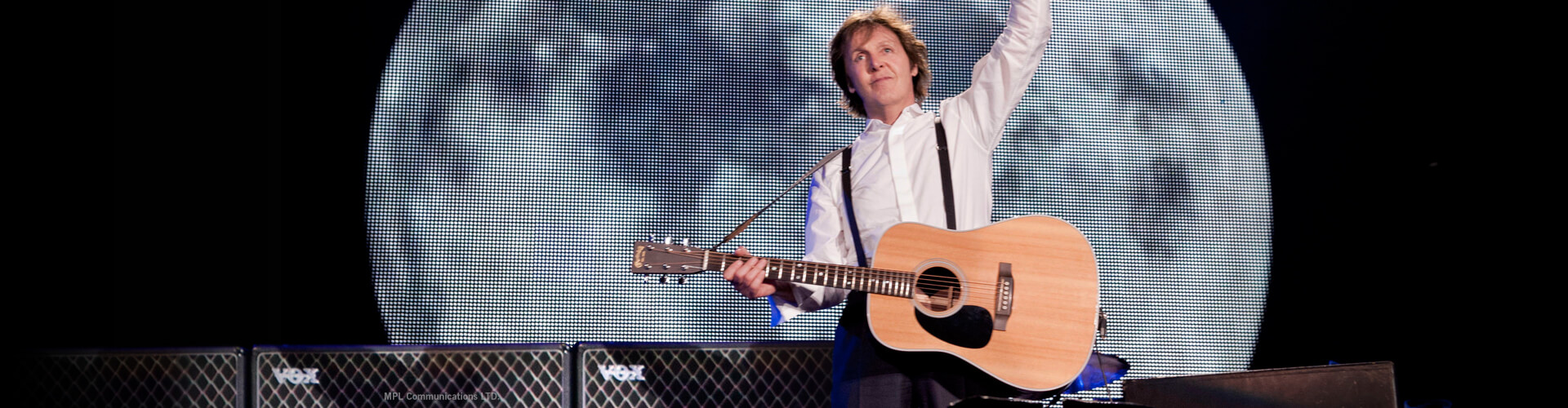 Paul Mccartney holding acoustic guitar