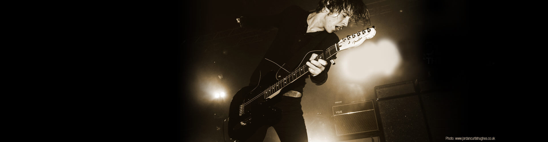 black and white pictire of artist, Van McCann, in concert playing electric guitar