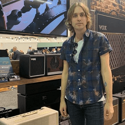 man standing next to various VOX products