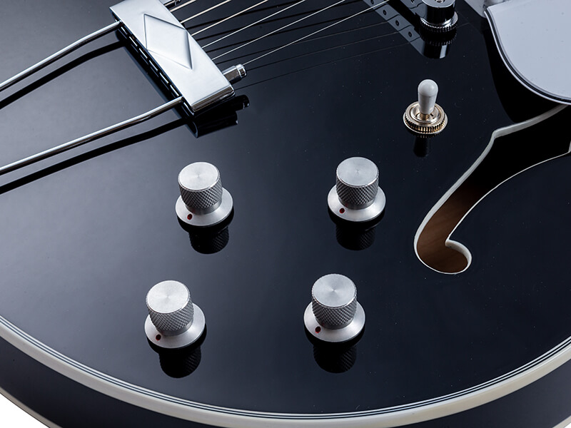closeup of knobs on black VOX electric guitar