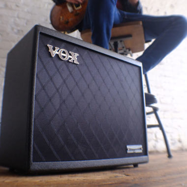 Vox Cambridge50 guitar modeling amp sitting on the floor in front of a man playing an electric guitar