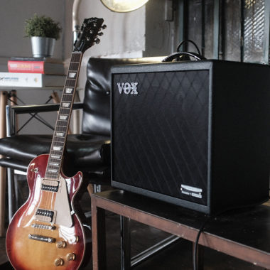 Vox Cambridge50 guitar modeling amp on a table next to a sunburst electric guitar