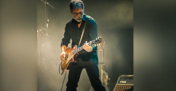 male musician playing electric guitar in concert