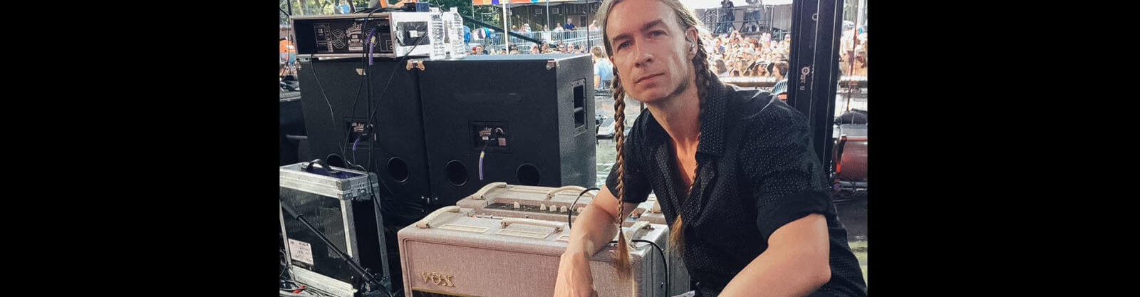 man backstage at concert leaning on VOX amplifier