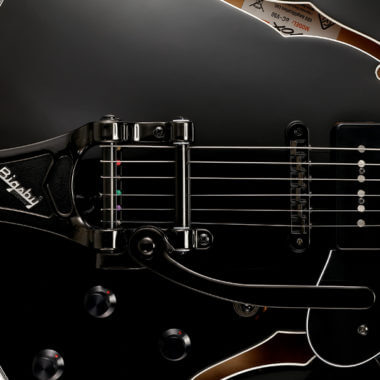 closeup of body of black electric guitar
