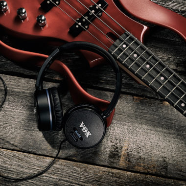 VOX headphones beside electric guitar