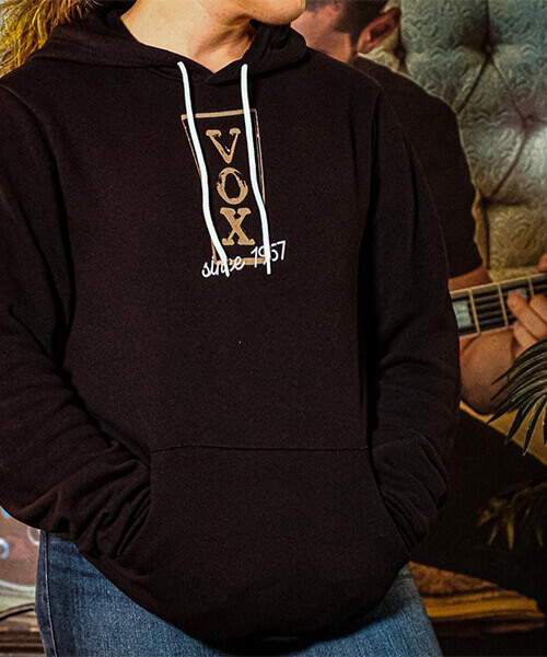 Person wearing Vox hoodie with hands in pockets