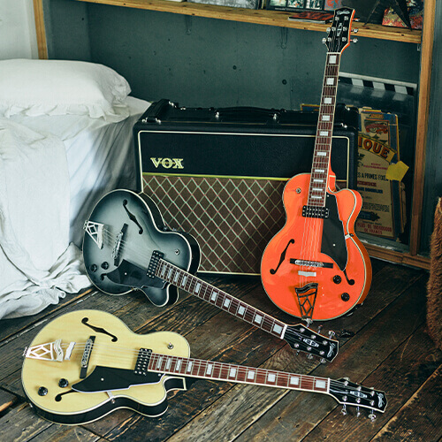Three different colors of Vox Giulietta Vga-5td Archtop Electric Guitar in a room with Vox amplifier.