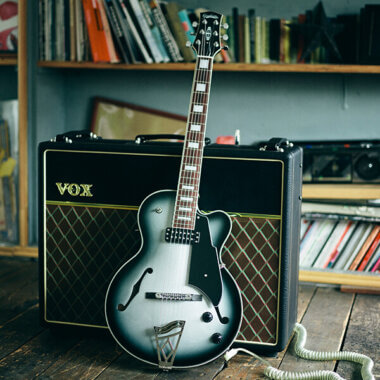 Vox Giulietta Vga-5td Archtop Electric Guitar Faded Silver leaning on Vox amplifier.
