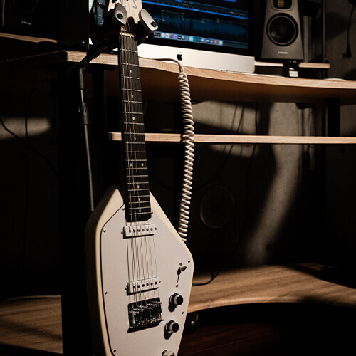 Vox Mark V Mini Guitar white in stand on studio desk.