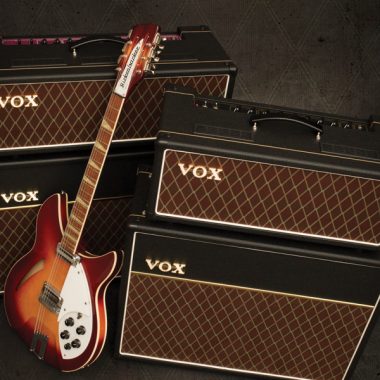 electric guitar leaning up against two VOX amplifiers