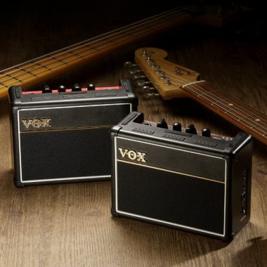 two VOX Bass Mini Amplifiers beside two basses