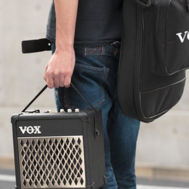 man carrying VOX amplifier and VOX gig bag