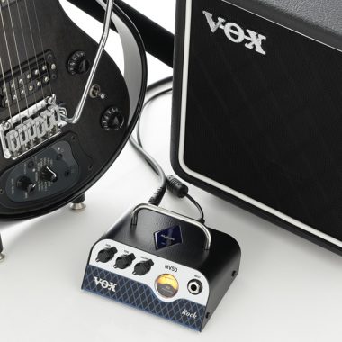 VOX Rock tube head between black VOX electric guitar and VOX amplifier